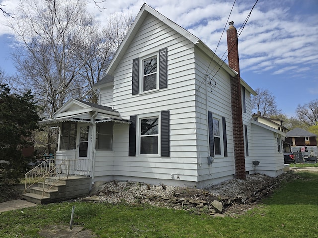 view of front facade with a chimney and a front yard