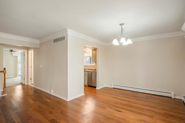 spare room featuring ceiling fan with notable chandelier, light hardwood / wood-style flooring, ornamental molding, and baseboard heating