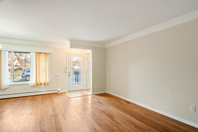 empty room with baseboard heating, a healthy amount of sunlight, crown molding, and light wood-type flooring