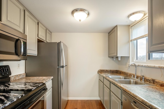 kitchen featuring gray cabinetry, sink, light hardwood / wood-style floors, and appliances with stainless steel finishes