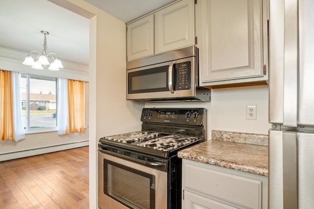 kitchen with an inviting chandelier, a baseboard heating unit, stainless steel appliances, light hardwood / wood-style floors, and decorative light fixtures