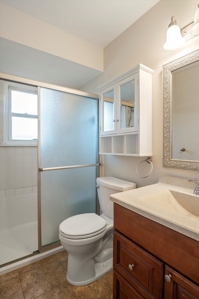 bathroom featuring tile patterned floors, vanity, toilet, and an enclosed shower