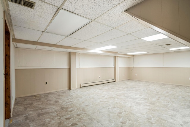 basement featuring baseboard heating and a paneled ceiling