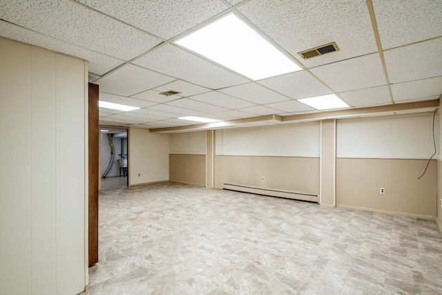 basement with a baseboard radiator and a paneled ceiling