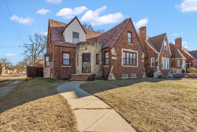 tudor-style house featuring a front lawn