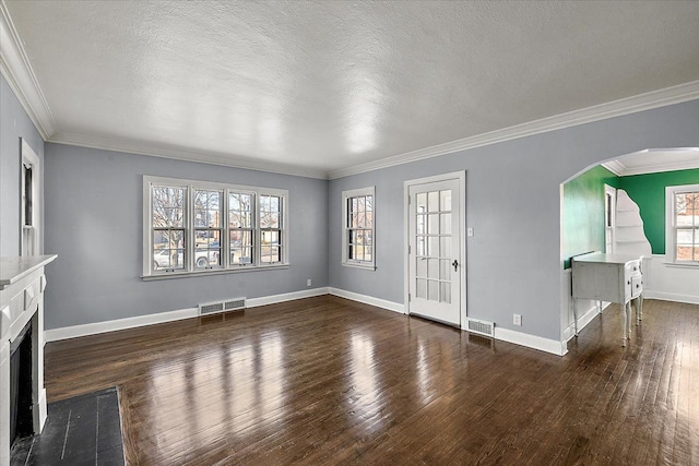 unfurnished living room featuring dark hardwood / wood-style floors, ornamental molding, and a textured ceiling