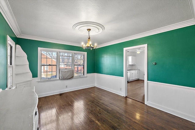 unfurnished dining area with ceiling fan with notable chandelier, dark hardwood / wood-style flooring, ornamental molding, and a textured ceiling