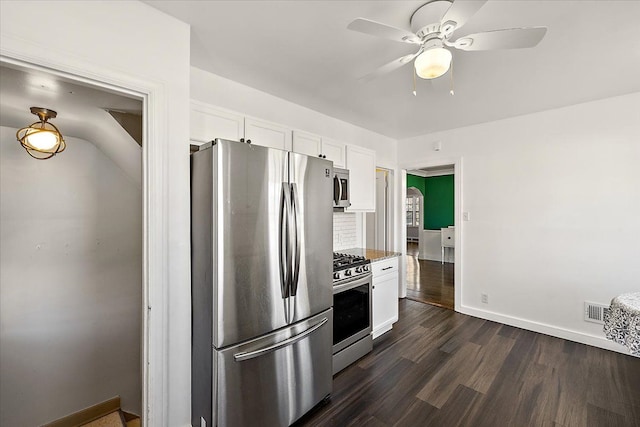 kitchen with ceiling fan, stone counters, dark wood-type flooring, white cabinets, and appliances with stainless steel finishes