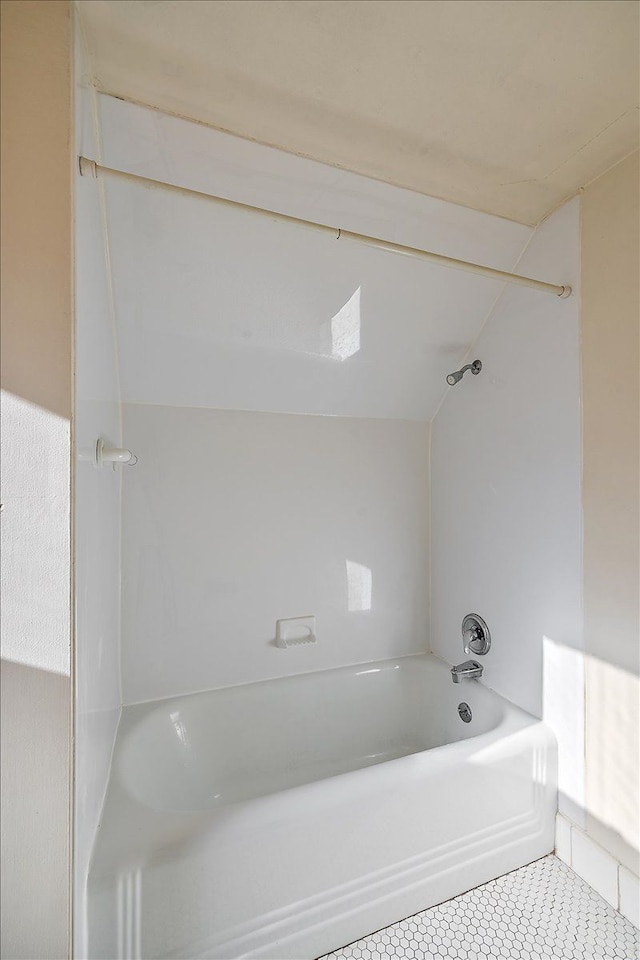 bathroom featuring lofted ceiling and bathtub / shower combination