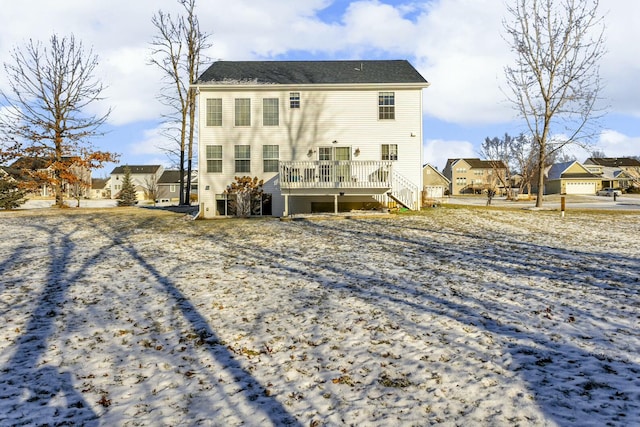 snow covered house with a wooden deck