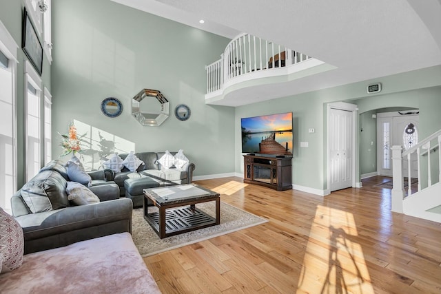 living room with wood-type flooring and a high ceiling