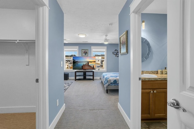 hallway featuring sink and light carpet