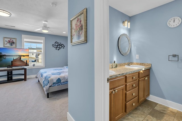 carpeted bedroom with ceiling fan and sink