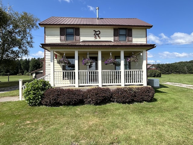 view of front facade featuring cooling unit, covered porch, and a front yard