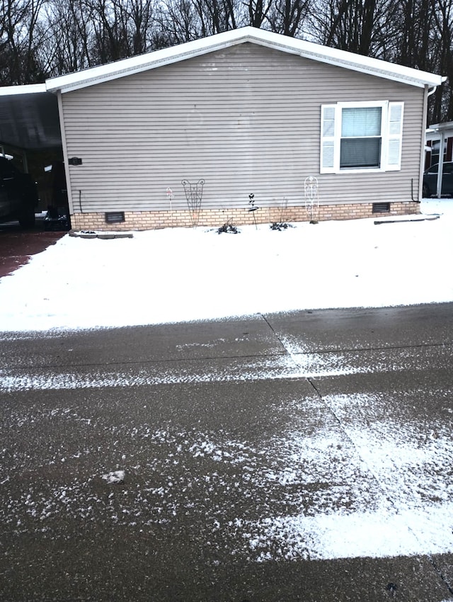 view of snow covered exterior featuring a carport