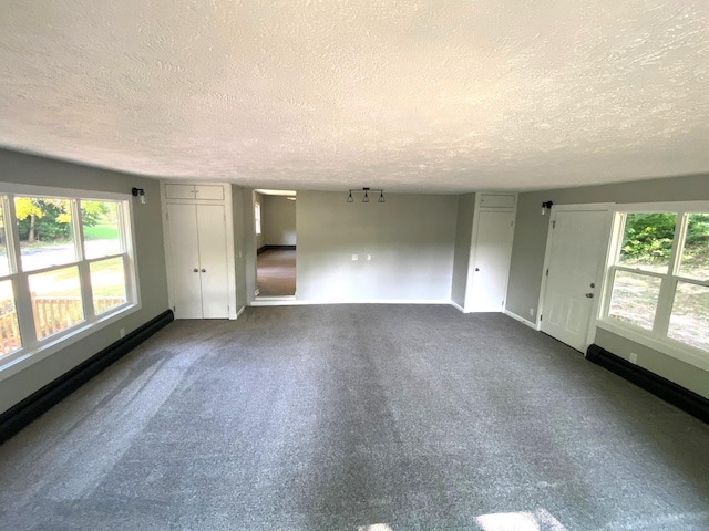 carpeted spare room featuring a healthy amount of sunlight and a textured ceiling