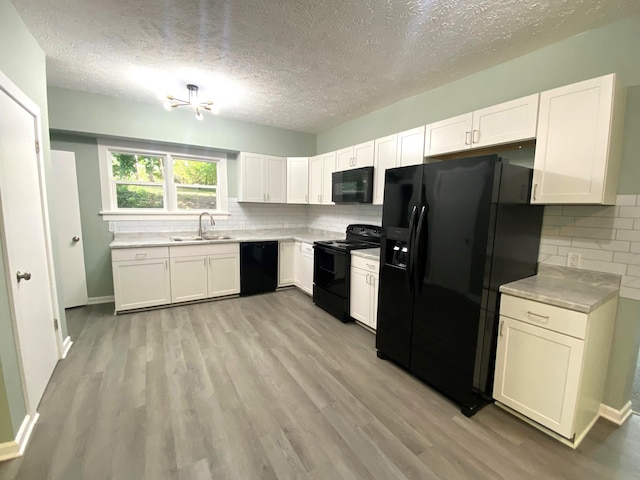 kitchen with tasteful backsplash, sink, white cabinets, and black appliances