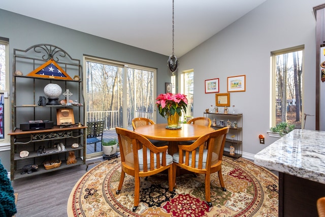 dining space with dark hardwood / wood-style flooring and vaulted ceiling