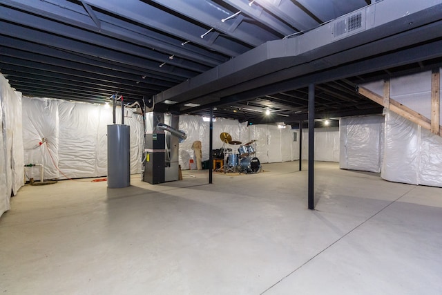 basement featuring heating unit and water heater