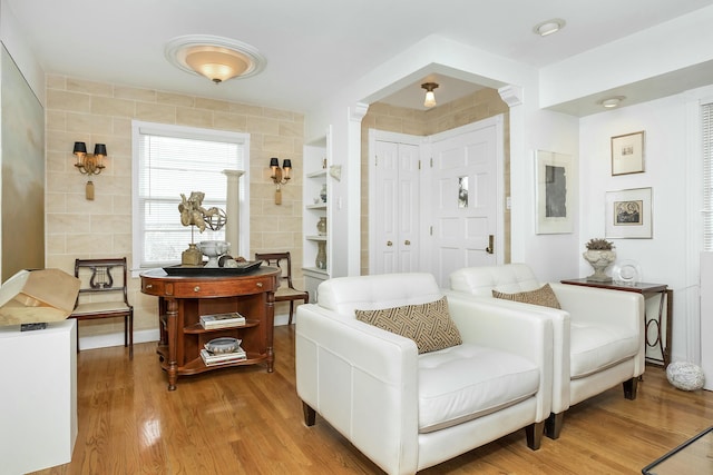 living area with hardwood / wood-style floors and tile walls