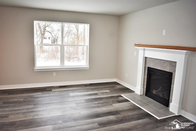 unfurnished living room with dark hardwood / wood-style flooring and a fireplace