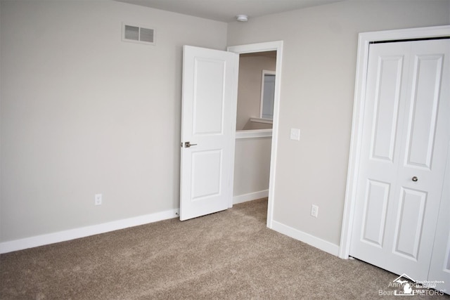 unfurnished bedroom featuring a closet and light carpet