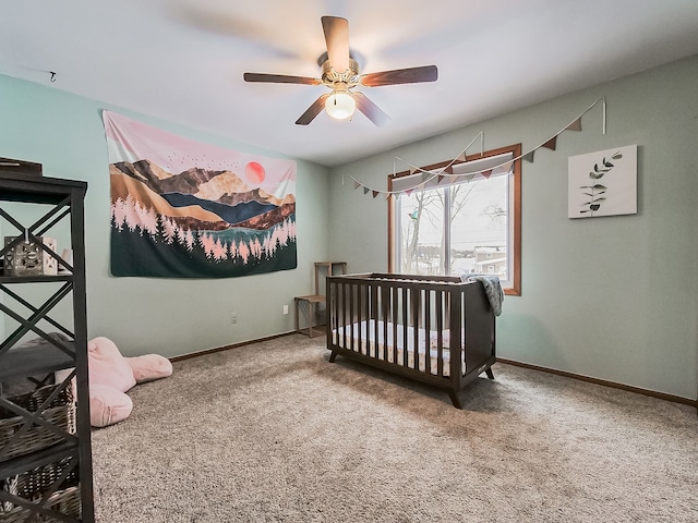 bedroom featuring a crib, ceiling fan, and carpet