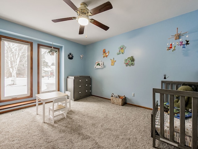 bedroom with a crib, ceiling fan, and carpet