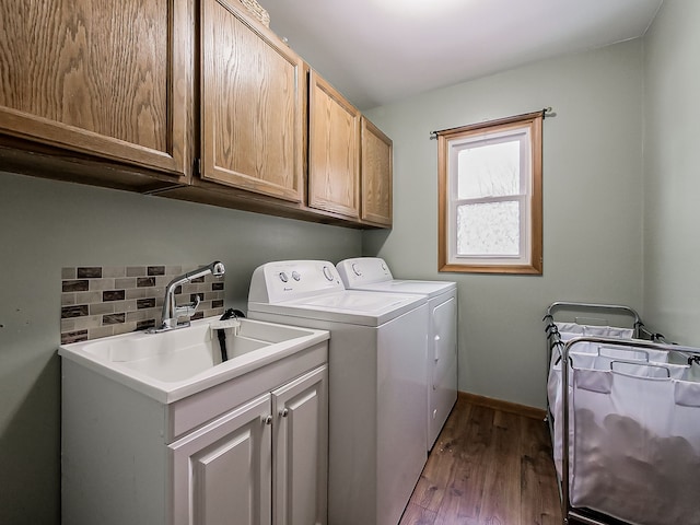 clothes washing area with light hardwood / wood-style floors, cabinets, sink, and independent washer and dryer