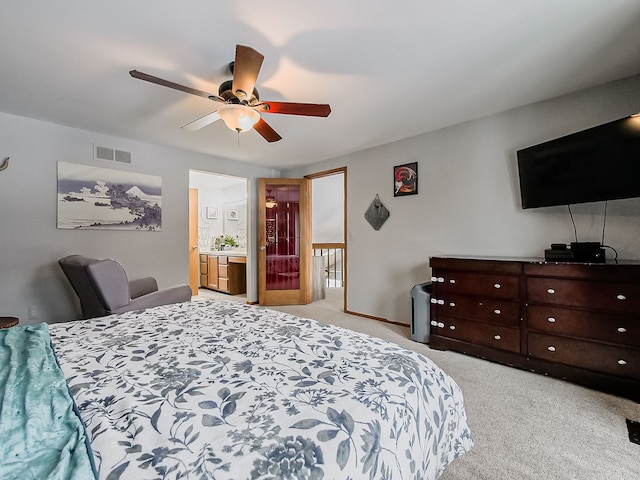 bedroom featuring ceiling fan, light colored carpet, and ensuite bathroom