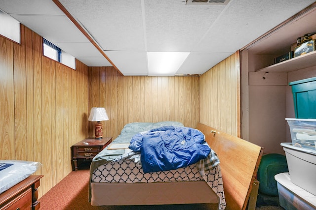 carpeted bedroom featuring wood walls