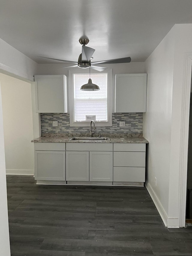 kitchen with decorative backsplash, sink, and white cabinetry