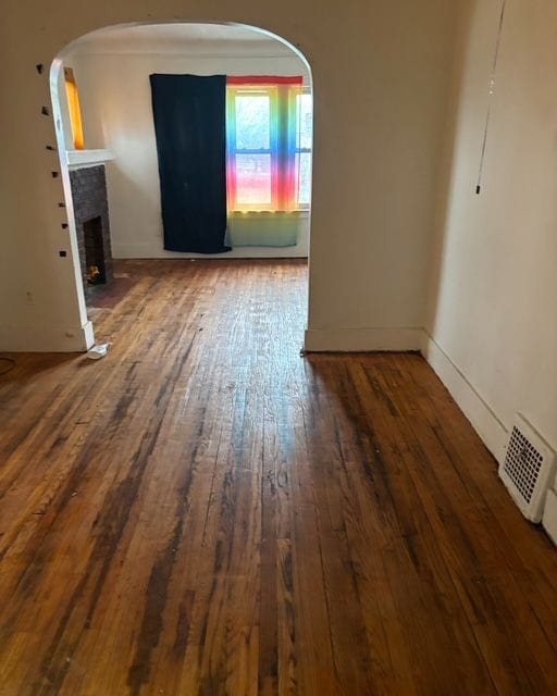 unfurnished room featuring hardwood / wood-style flooring and a fireplace