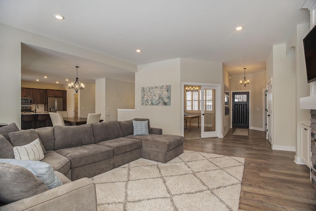 living room featuring dark hardwood / wood-style flooring, sink, and an inviting chandelier