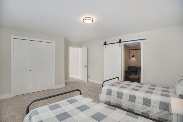 bedroom with a barn door, light carpet, and a closet