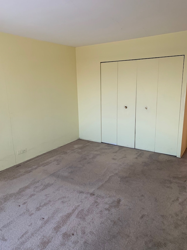 unfurnished bedroom with carpet flooring and a closet