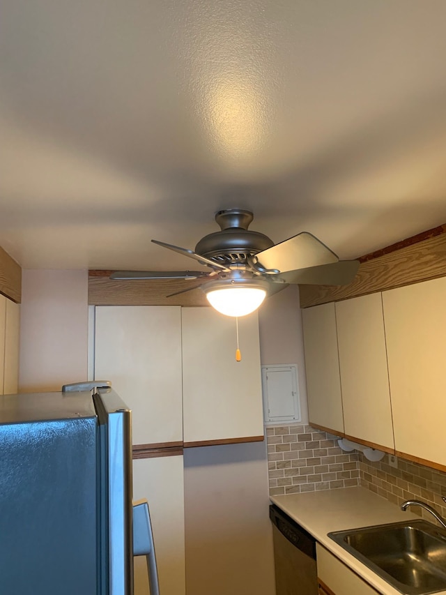 kitchen featuring backsplash, stainless steel dishwasher, sink, and ceiling fan