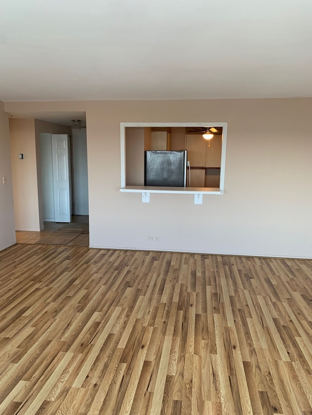 unfurnished living room featuring ceiling fan and hardwood / wood-style floors