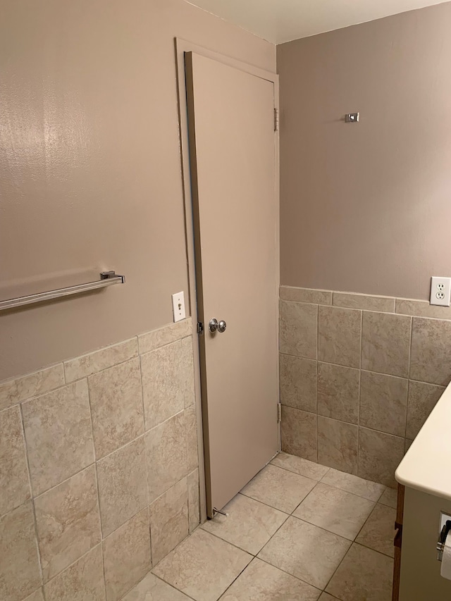 bathroom with tile patterned floors and tile walls