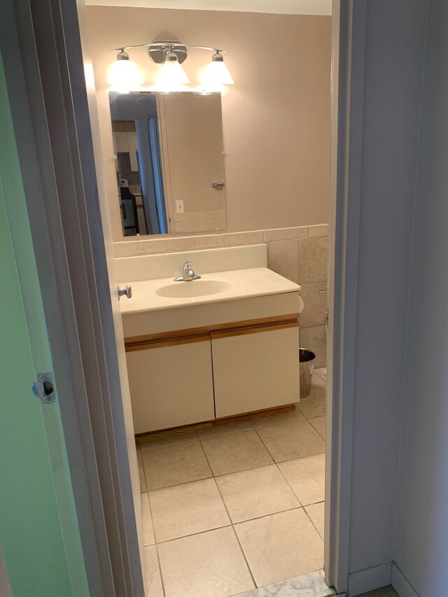 bathroom featuring vanity, tile patterned floors, and tile walls