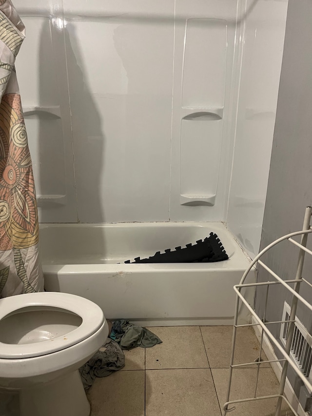 bathroom featuring toilet, shower / bath combo, and tile patterned floors