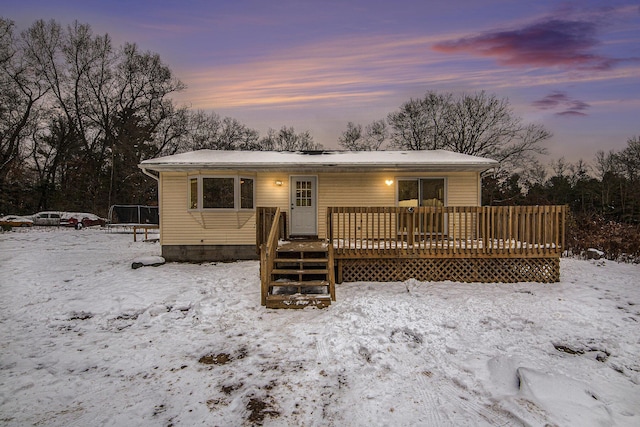 view of front of home featuring a wooden deck and a trampoline