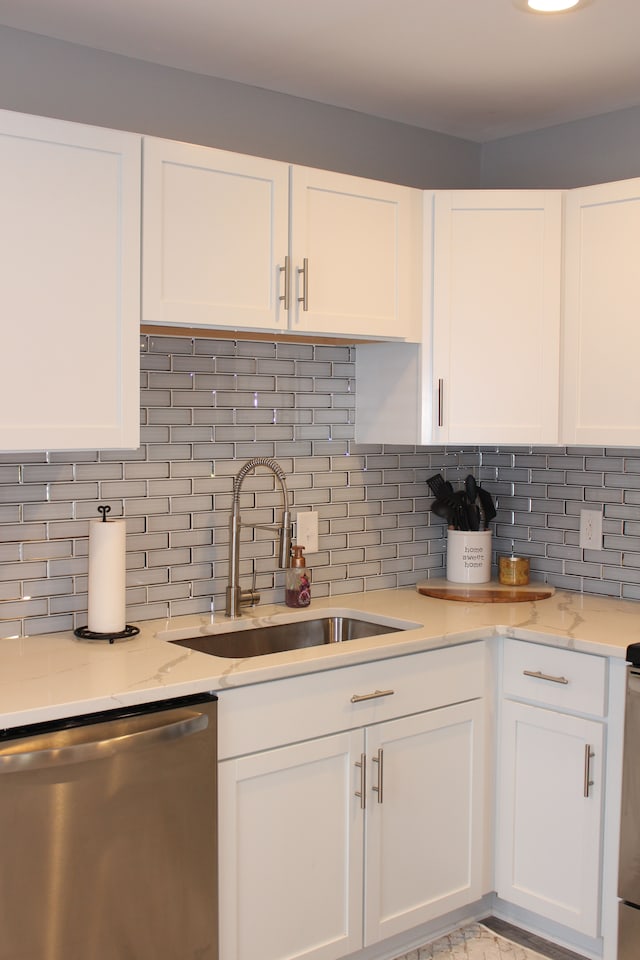 kitchen with dishwasher, white cabinetry, decorative backsplash, and sink