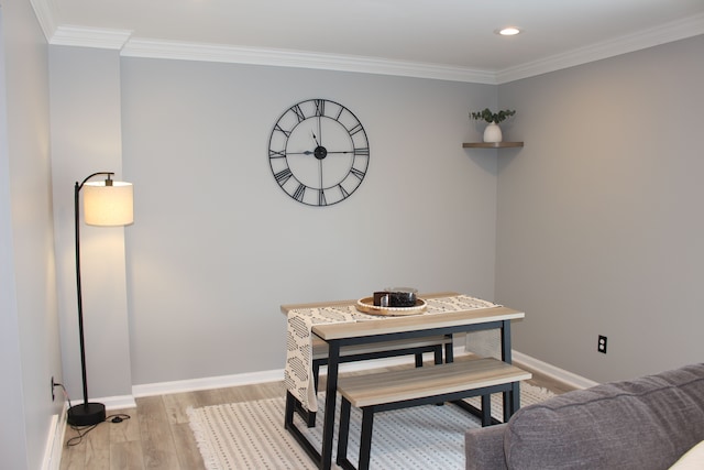 dining space with crown molding and light hardwood / wood-style flooring