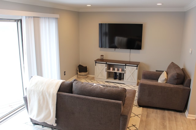 living room featuring light wood-type flooring, plenty of natural light, and crown molding