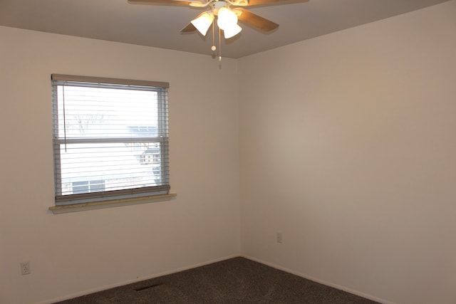 spare room featuring carpet flooring, a wealth of natural light, and ceiling fan