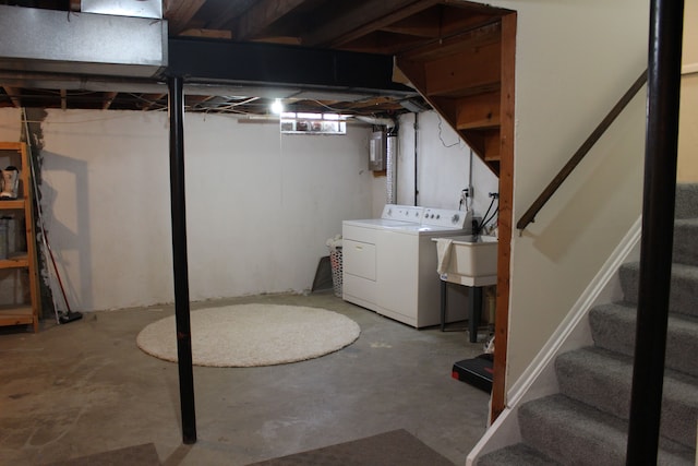 basement featuring sink, electric panel, and washing machine and clothes dryer