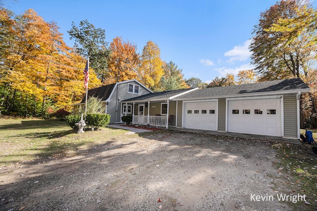 view of front of home with a front yard, a porch, and a garage