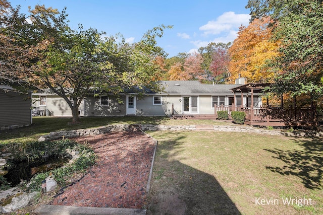 rear view of house featuring a lawn, a pergola, and a deck