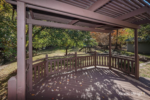 wooden terrace with a playground and a yard